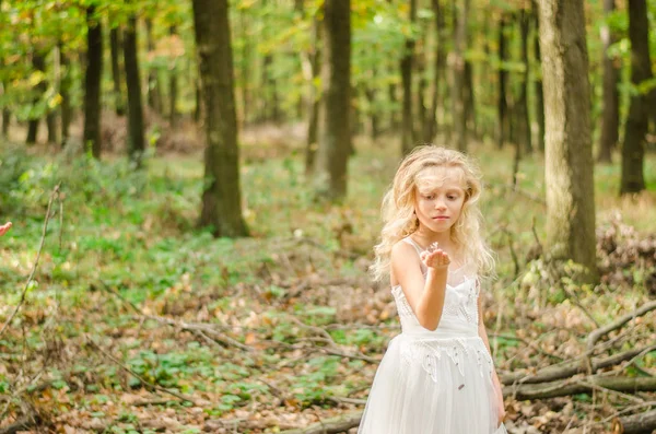 Adorable niño en vestido de novia largo y blanco con mariposa en las manos —  Fotos de Stock