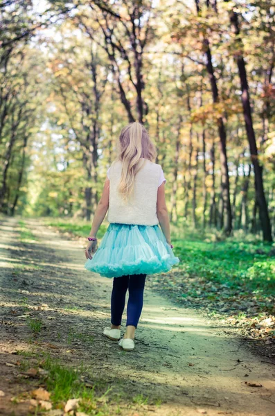 Adorabile ragazza bionda in gonna tutù blu nella foresta — Foto Stock