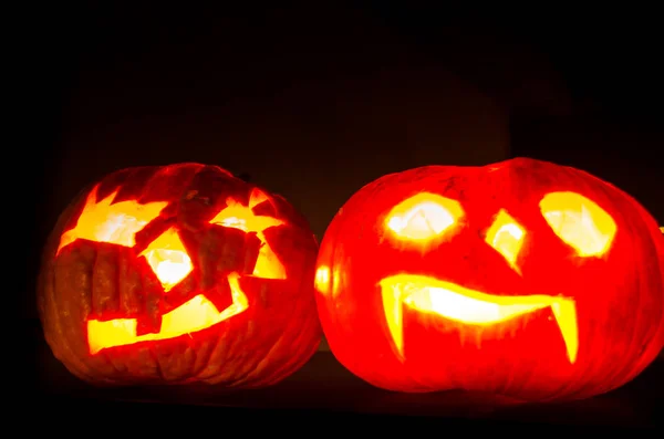 Beleuchtete gruselige Halloween-Kürbisse leuchten in dunkler Nacht — Stockfoto