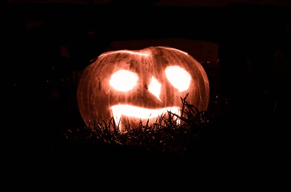 Beleuchtete gruselige Halloween-Kürbisse leuchten in dunkler Nacht — Stockfoto