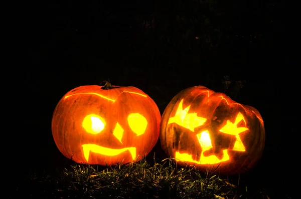 Beleuchtete gruselige Halloween-Kürbisse leuchten in dunkler Nacht — Stockfoto