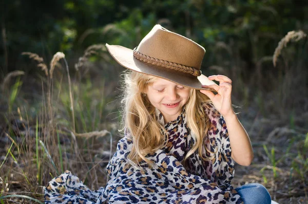 Litet barn med långt blont hår och hatt — Stockfoto