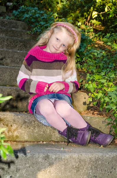 Entzückendes Kind sitzt auf der Treppe — Stockfoto