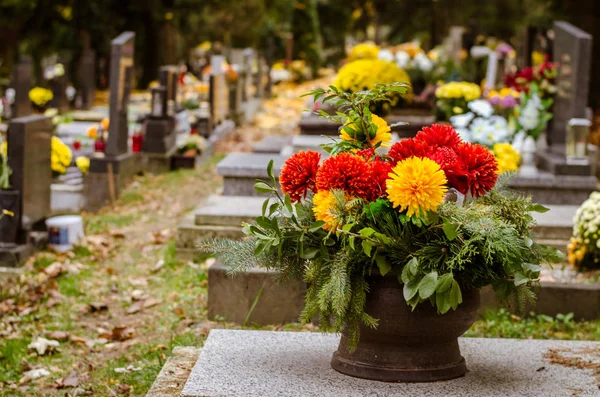 Blumen auf Gräbern zu Allerheiligen auf dem Herbstfriedhof — Stockfoto