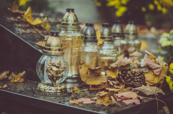 Burning candles and autumnal colorful leaves on the grave — Stock Photo, Image