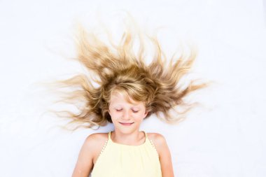 Uzun sarı saçlı, güneş şeklinde gözleri kapalı gülümseyen çocuk fotokopi alanı gibi.