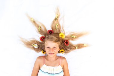 Kuşların bakış açısından çiçeklerle süslenmiş sevimli, uzun saçlı çocuk.