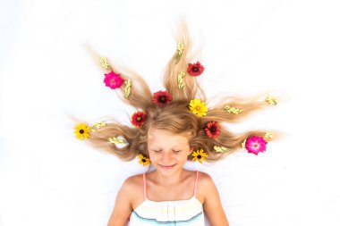 Çiçek desenli, uzun sarı saçlı sevimli bir çocuk. Kuşlar tarafından çekilmiş.