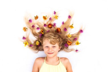 Sevimli, gülümseyen bir çocuk, sağlıklı ve güçlü uzun sarı saçları var. Çiçek fikirleriyle süslenmiş güneş şeklinde.