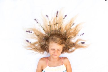 Uzun sarı saçlı, lavanta süslemeli tatlı bir çocuk. Kuşlar tarafından çekilmiş.