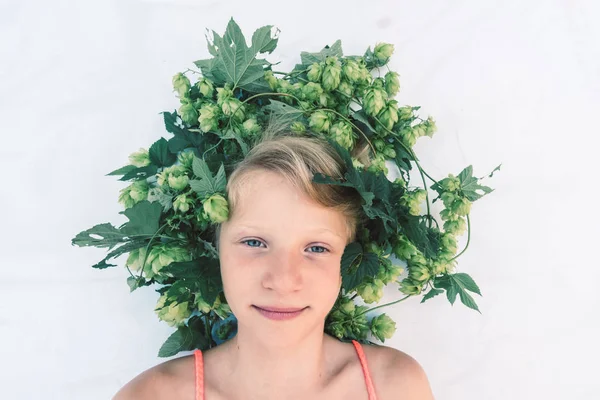 Encantadora criança sorridente com decoração de lúpulo na cabeça no cabelo — Fotografia de Stock