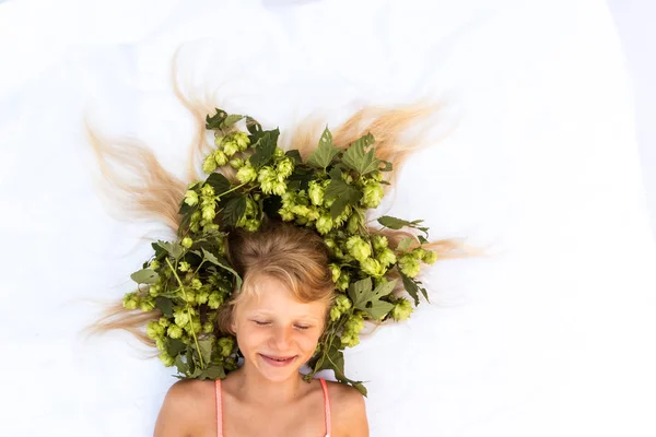 Encantadora niña sonriente con decoración de lúpulo en la cabeza en el pelo — Foto de Stock