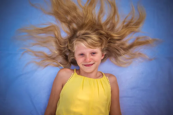 Affascinante sorridente bambino lungo capelli biondi a forma di sole — Foto Stock