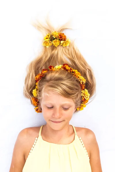 Schattig lachend kind met gezond en sterk lang blond haar in de vorm van vreugdevuur versierd met bloemen hoofdband kopieerruimte — Stockfoto