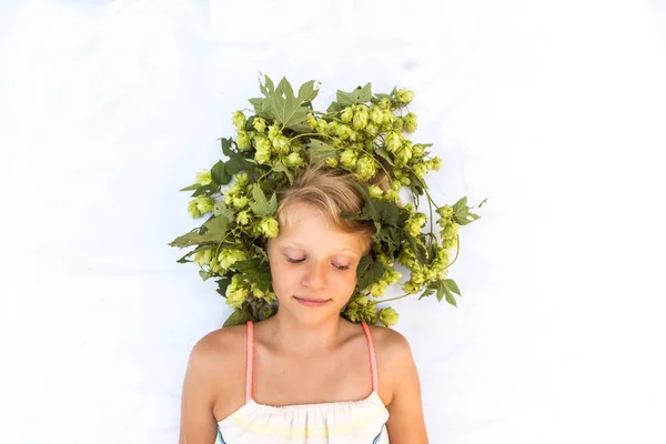 Encantadora niña sonriente con decoración de lúpulo en la cabeza en el espacio de copia de pelo ojos cerrados — Foto de Stock