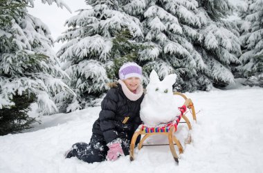 Çocuk kış tatilinde çok fazla kar ve küçük kardan adam ustalıkla inşa edilmiş