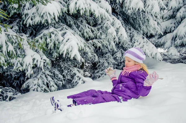 Küçük kız kış doğasında çok fazla karla eğleniyor. — Stok fotoğraf