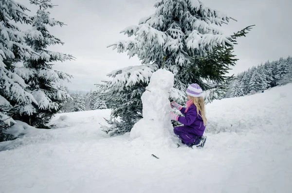 Adorable adolescente niño divirtiéndose en feliz invierno con mucha nieve y poco muñeco de nieve — Foto de Stock