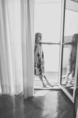 çocuk perdenin arkasındaki balkonda.