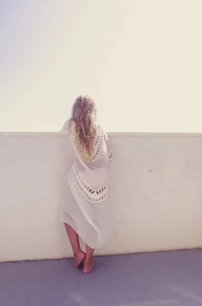 Adorable girl with long blond hair looking from the balcony to the blue croatian sea — Stock Photo, Image