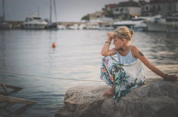 Caucasiano loira menina sozinho e triste pelo mar a partir da costa — Fotografia de Stock
