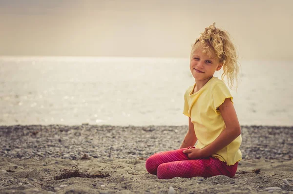 可爱的金发姑娘一个人在海边的空旷沙滩上放松 — 图库照片