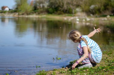 Sevimli şirin çocuk su kenarında dinleniyor.