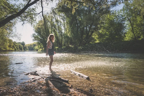 可愛いですブロンド女の子遊びますとともに水で浅い水で晴れた夏の日 — ストック写真