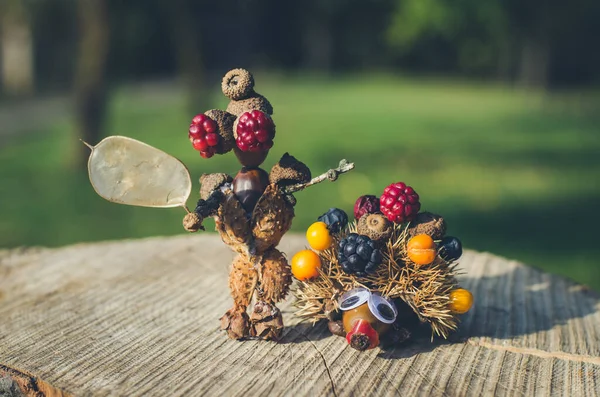 Kestaneden tatlı bir figür, yapraklar ve çiçekler canlı sonbahar renklerinde.
