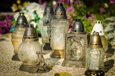 Mezardaki fenerlerde mum yakmak güneşli bir öğleden sonra boyunca renkli sonbahar atmosferiyle