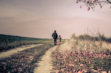 Baba ve kızı karanlık bir öğleden sonra dramatik kırsal yolda yalnızlar.