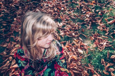 Güzel sonbahar mevsiminde uzun sarı saçlı güzel kız mutlu bir öğleden sonra geçiriyor.