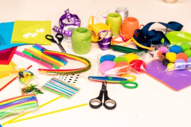 Renkli kağıtlar, makas, yapıştırıcı, kamış, kurdele, kurdele, dantel masa üzerinde Noel tebrik kartları oluşturmaya hazırlanıyor.