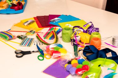 Renkli kağıtlar, makas, yapıştırıcı, kamış, kurdele, kurdele, dantel masa üzerinde Noel tebrik kartları oluşturmaya hazırlanıyor.