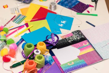 Renkli kağıtlar, makas, yapıştırıcı, kamış, kurdele, kurdele, dantel masa üzerinde Noel tebrik kartları oluşturmaya hazırlanıyor.