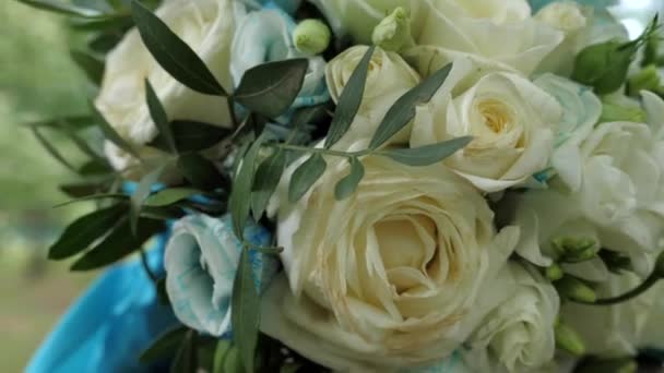 Een Boeket Van Bloemen Gebonden Met Een Cyaan Lint Ligt — Stockvideo