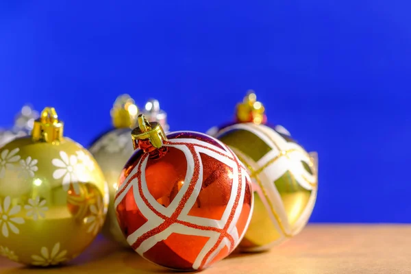 Close up christmas balls ornaments on blue background and wood table.