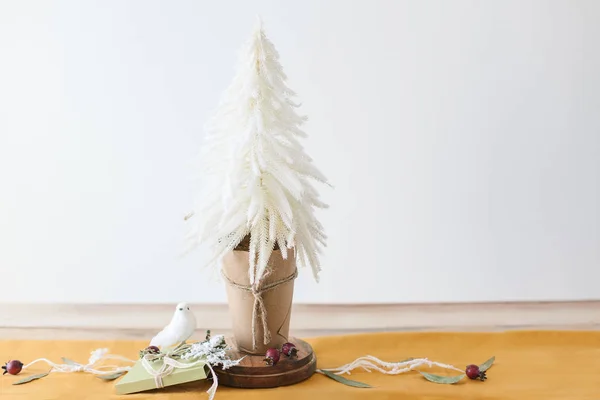 Modern Christmas table decor - Christmas tree, mustard table runner, pine cones, apples, birds, branches with snow