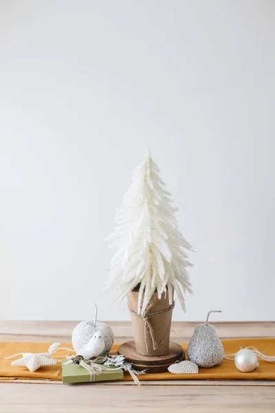 Décor de table de Noël moderne - sapin de Noël, chemin de table moutarde, cônes de pin, pommes, oiseaux, branches avec neige — Photo
