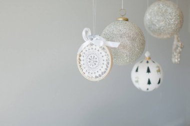 Gri arka planda asılı birkaç Noel süsü
