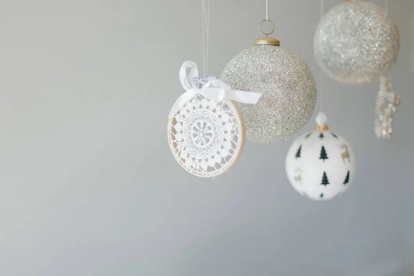 Plusieurs ornements de Noël suspendus sur un fond gris — Photo