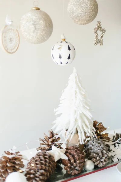 Winterliche Tischdekoration mit Mini-Weihnachtsbaum, Tannenzapfen und Ornamenten — Stockfoto