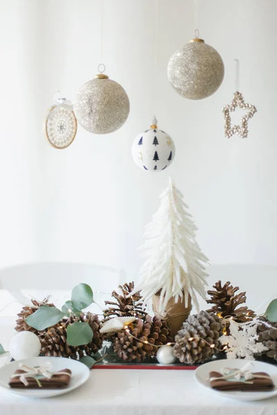 Winter table decoration with mini Christmas tree, pine cones and