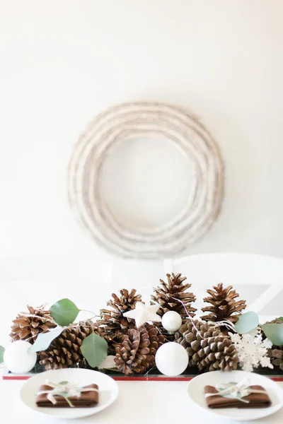 Kersttafel met dennenappels, witte ornamenten en rus — Stockfoto