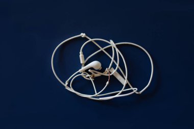 Kopya alanı ile koyu mavi arkaplan üzerinde kırık ve karışık kulaklıklar.