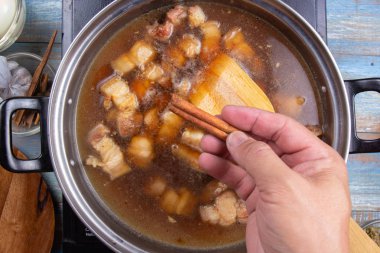 Baharat pişirme çizgili domuz için tencereye koyarak / tatlı kahverengi Komposto domuz eti sos (Moo Pa-lo) kavramı pişirme Şef