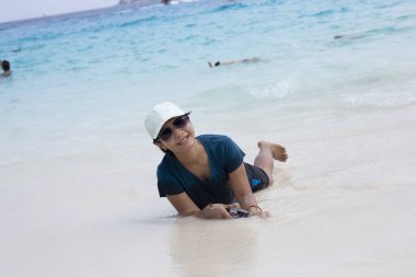 Asyalı kadın zevk mavi deniz ile sahilde