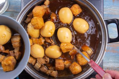 Çizgili domuz kase tencereye koyarak / tatlı kahverengi Komposto domuz eti sos (Moo Pa-lo) kavramı pişirme Şef