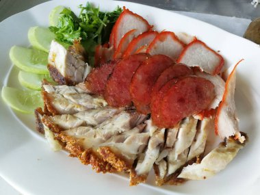 Kırmızı domuz, gevrek domuz eti ve salatalık ile tabakta sosis Çin tarzı ızgara