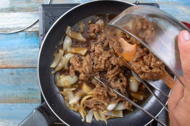 Şef koymak kaydırmak için pişmiş sığır eti dilim / Japon yemek pişirme Gyudon kavramı